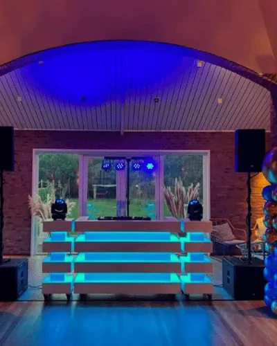 50 jaar feest organiseren: DJ-booth met ballonpilaren in een feestzaal