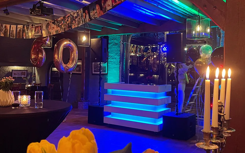 Abraham feest: verlichte DJ-booth op een verjaardag in een feestzaal