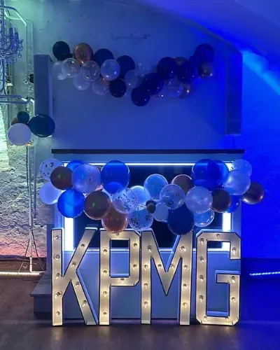 DJ bedrijfsfeest: DJ-booth van BOAZ met KPMG-letters en ballonnen op een bedrijfsfeest