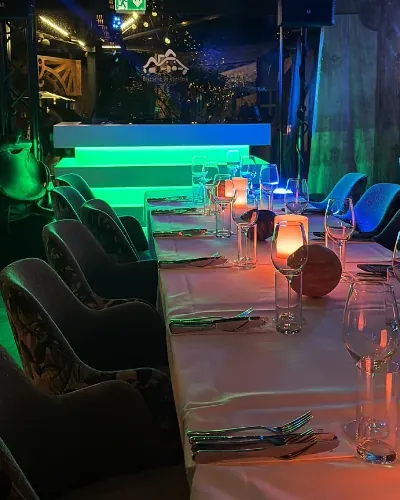 Groen verlichte DJ-booth naast de dinertafel van een feest