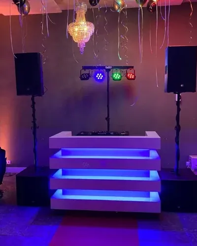 DJ-booth met blauw licht in een feestzaal met kroonluchter