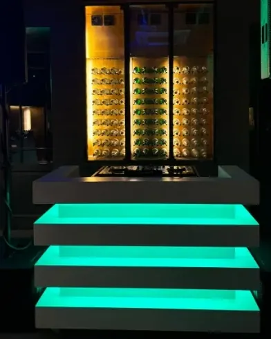 Groen verlichte DJ-booth voor een gouden wand
