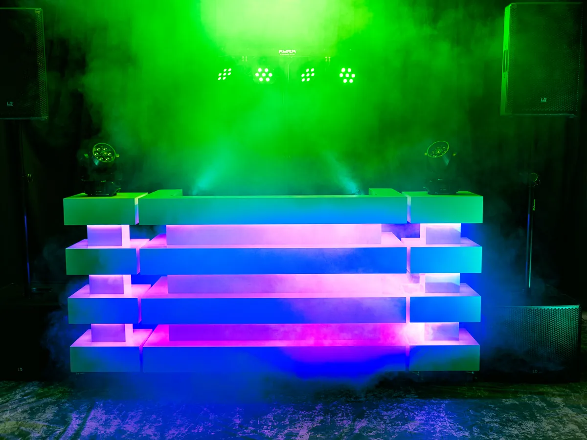 DJ huren Apeldoorn: verlichte DJ-booth van BOAZ met groen licht en rookeffect