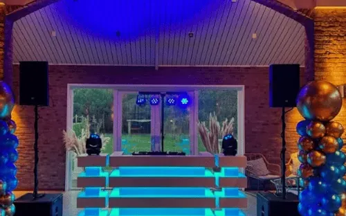 DJ huren verjaardag: DJ-booth met ballonpilaren in een feestzaal