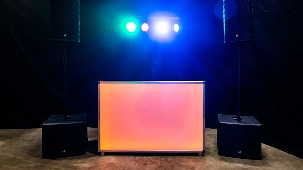 DJ Loenen: oranje verlichte DJ-booth met speakers