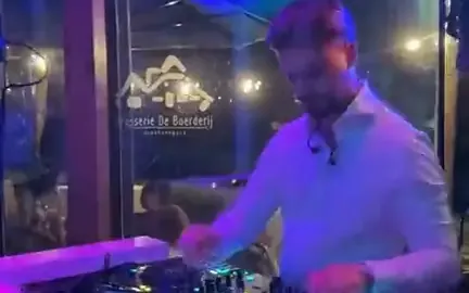 DJ voor studentenfeest: DJ draait achter een verlichte booth
