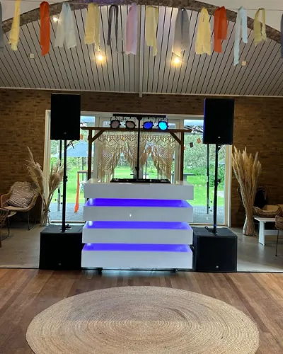 Familiefeest organiseren: DJ-booth in een verbouwde schuur met vlaggetjes