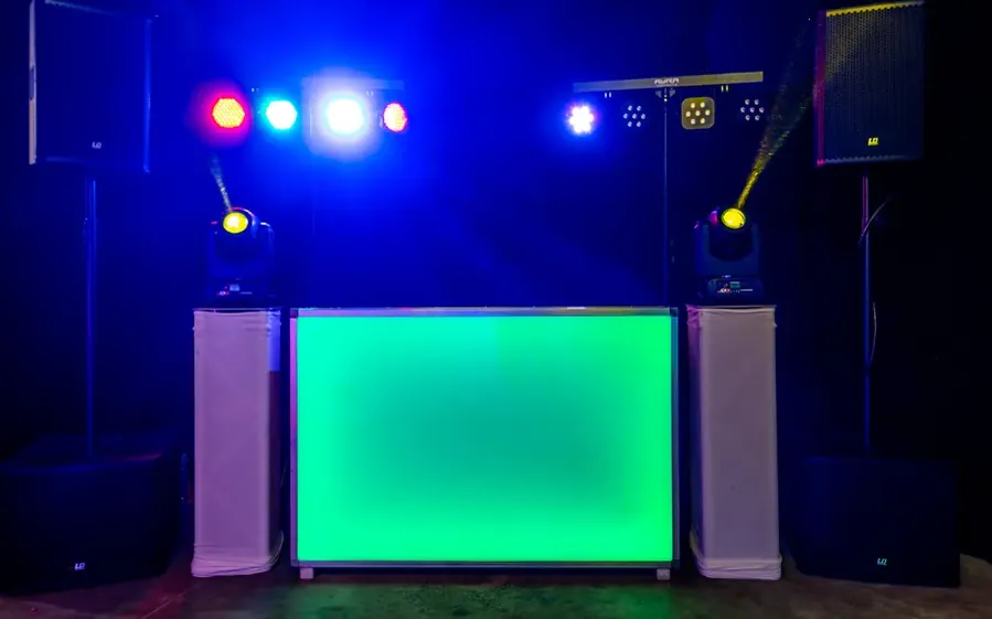 Pioneer set huren: groen verlichte DJ-booth met speakers en lichteffecten