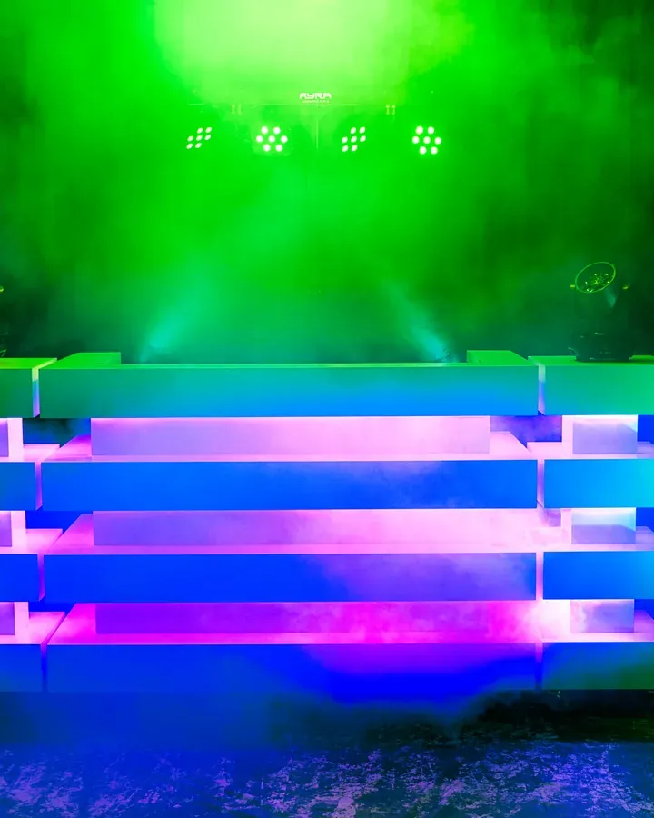 Verenigingsfeest organiseren: DJ-booth met groen licht en rook