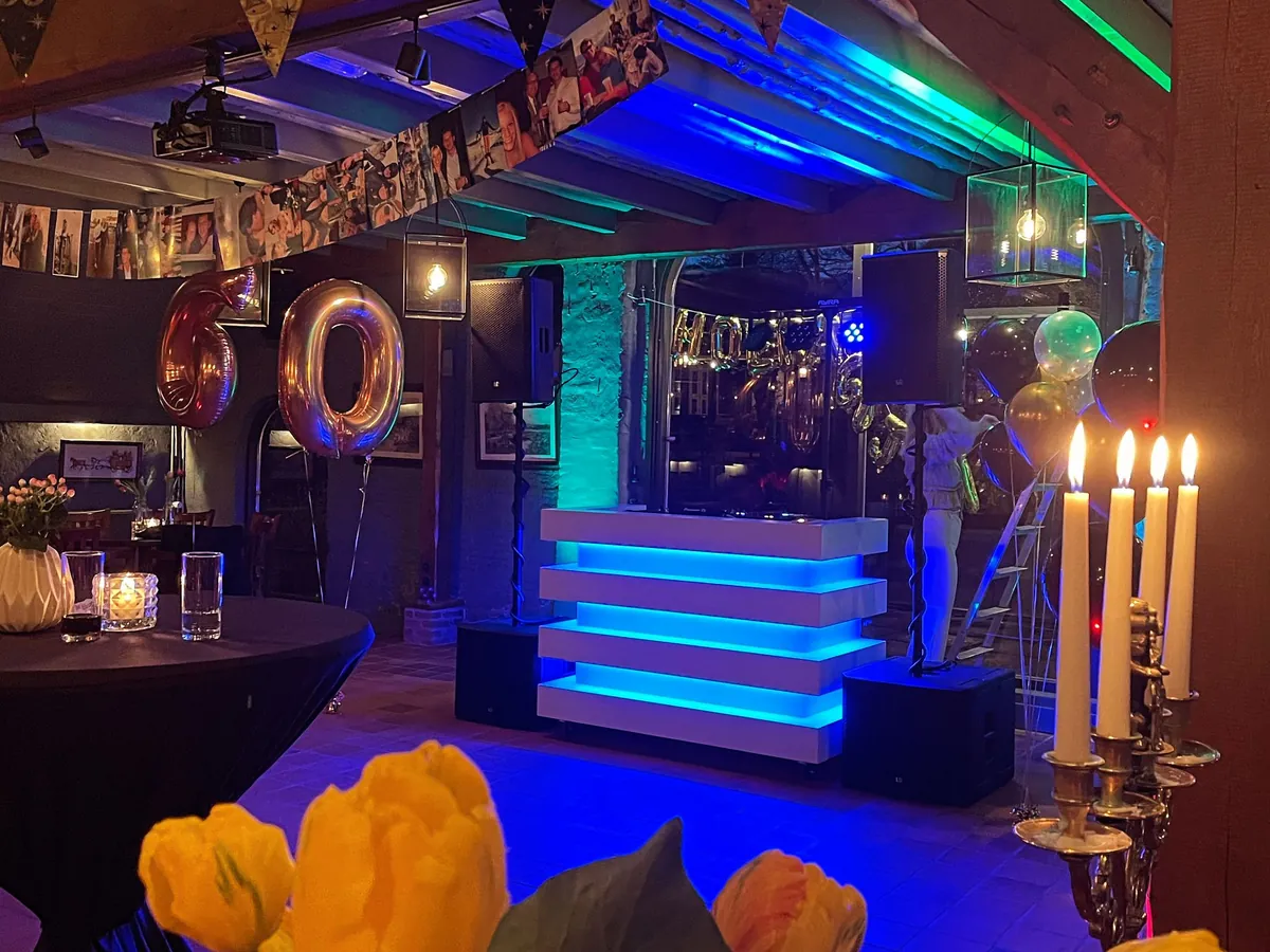 Verjaardag DJ: verlichte DJ-booth op een 60e verjaardag in een feestzaal