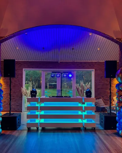 Verjaardagsfeest organiseren: DJ-booth met ballonpilaren in een feestzaal