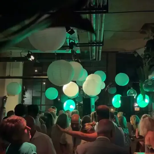 Gasten op een volle dansvloer onder lampionnen